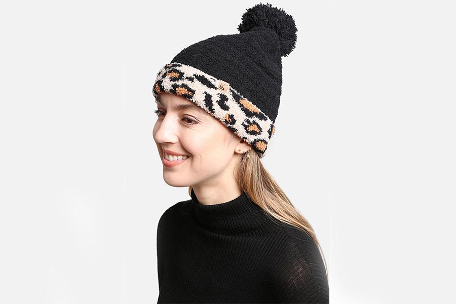 Woman smiling in a leopard-print bobble hat