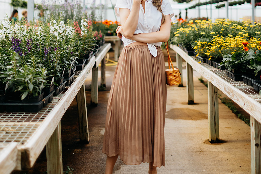 woman standing in a garden with brown boho skirt