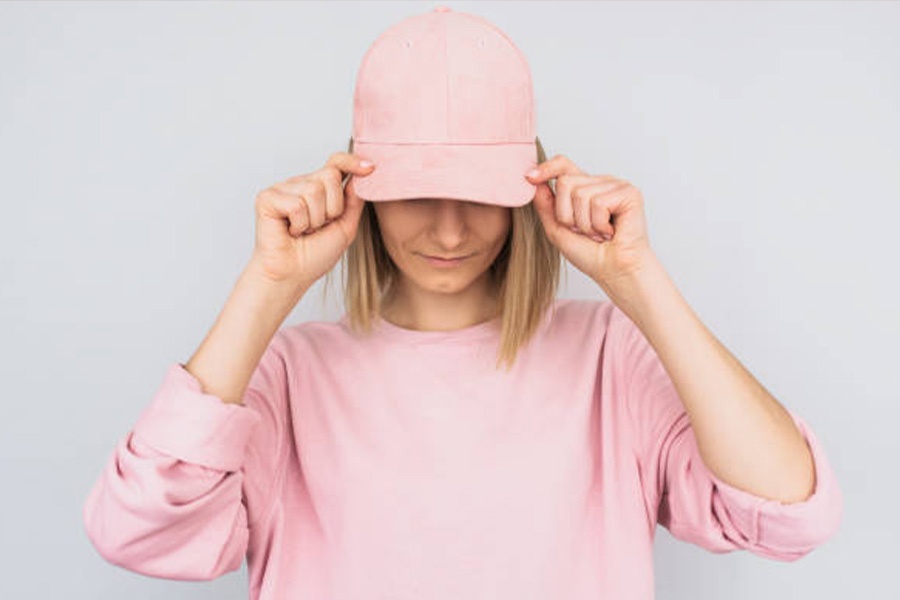 Woman wearing a pink baseball hat and pink sweater