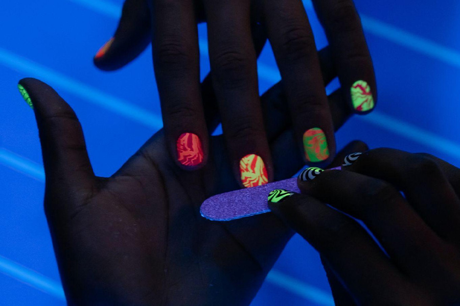 Woman's hand with blacklight nail polish.