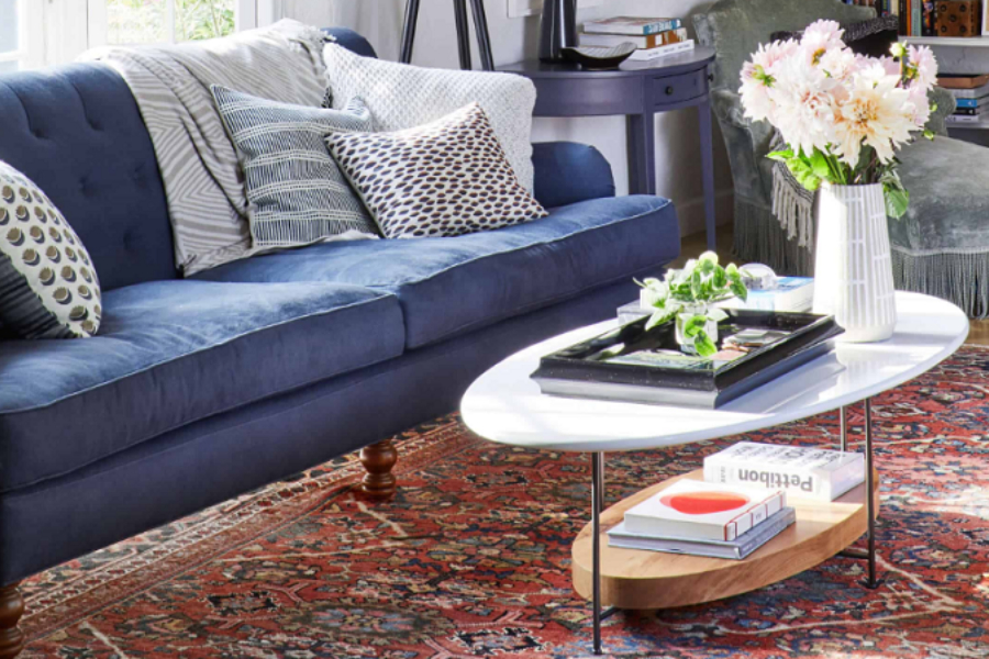 A blue English Club sofa in a spacious room with an area rug