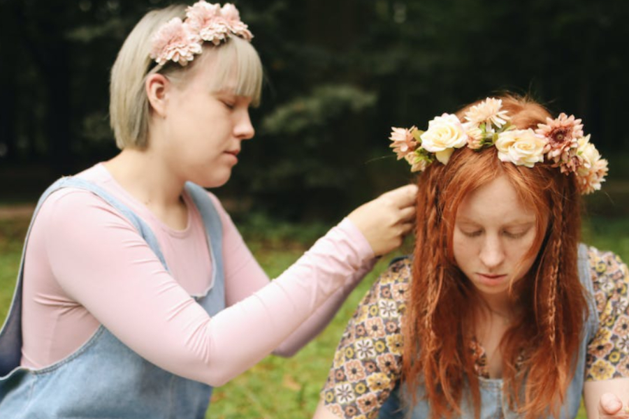 A lady wearing a headband on her friend's head
