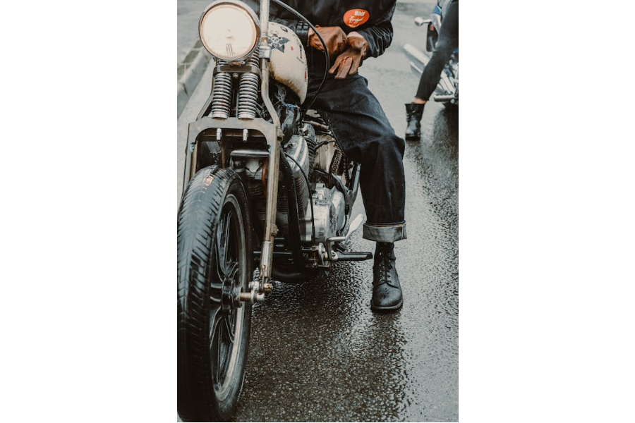 A man in black denim jeans on a motorcycle