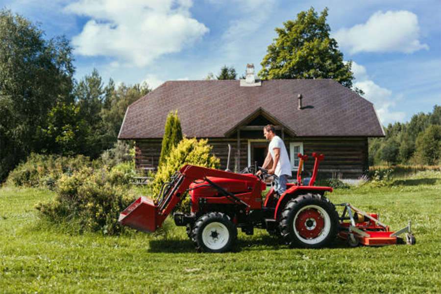 A man on a tractor cutting grass