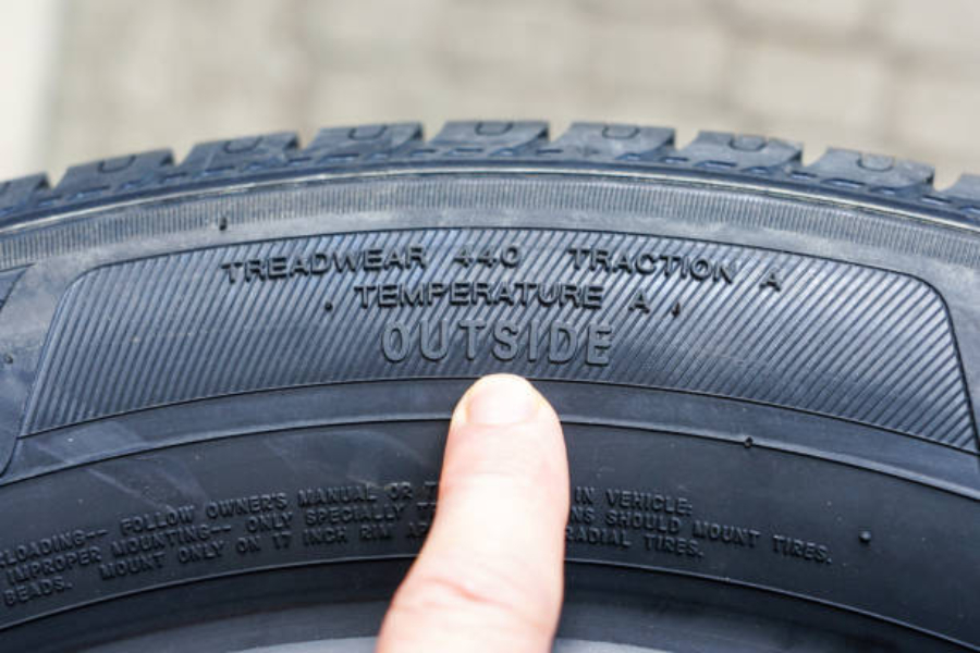 A side-view of a new tire with the treadwear index