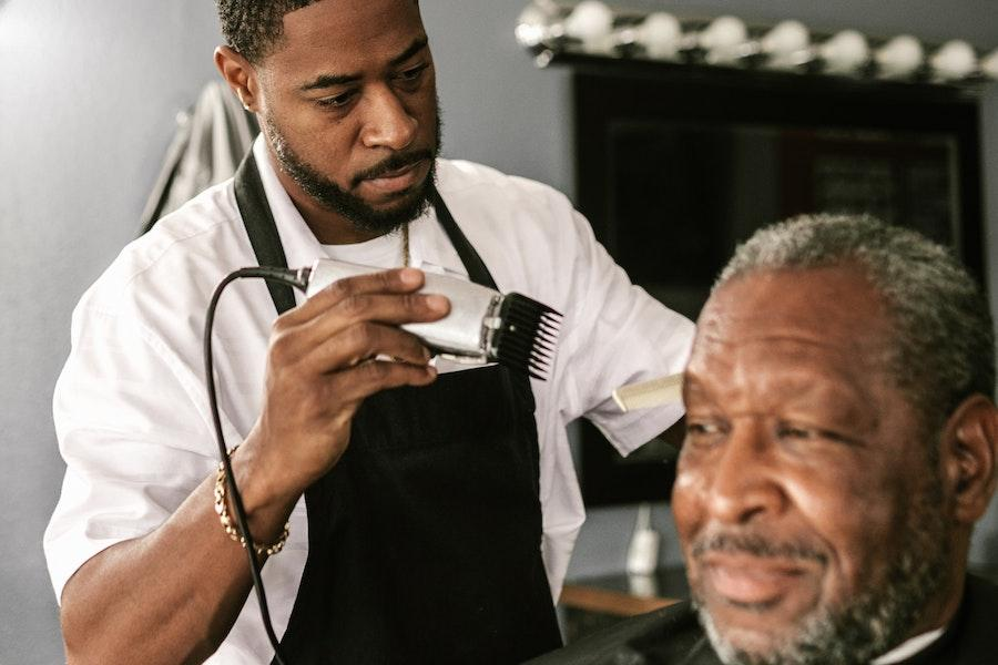 Barber giving a haircut with a corded clipper