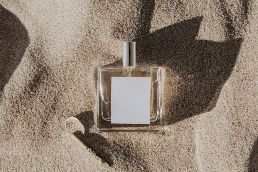 Close-up of a perfume in the sand
