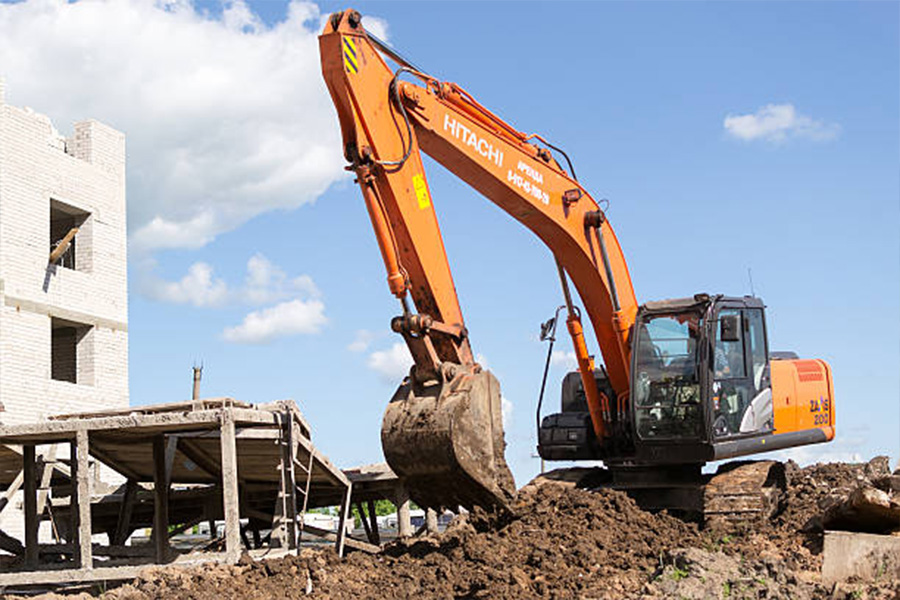 Hitachi orange digger excavates soil in preparation of new apartments