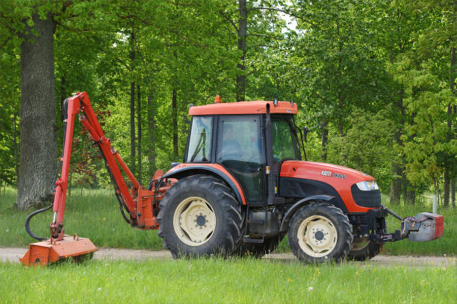 Kioti tractor mows grass in a park