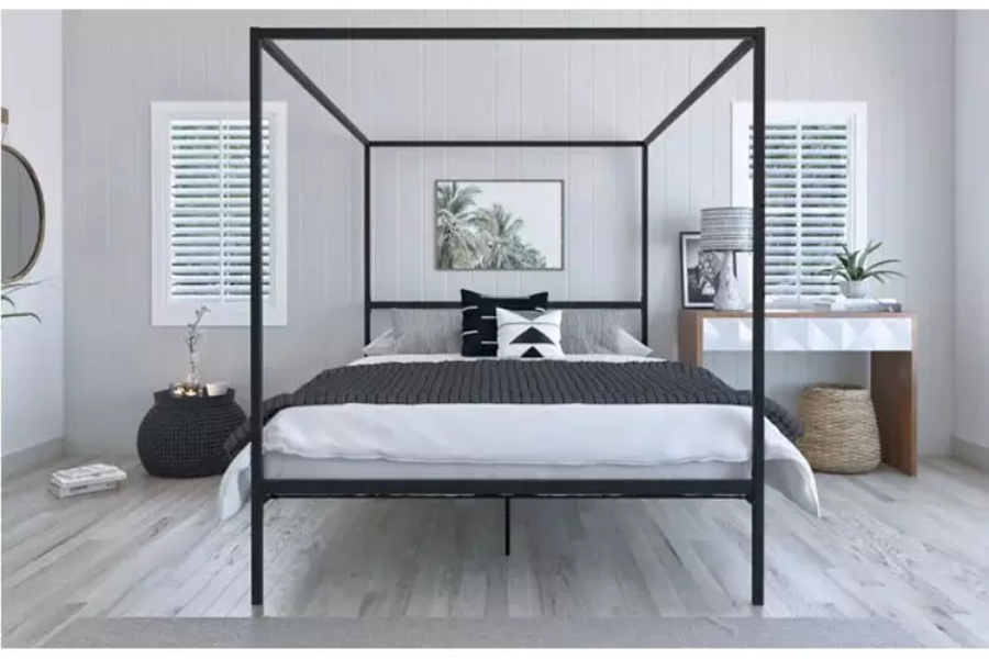 Large four-poster metal bed with a black thin frame