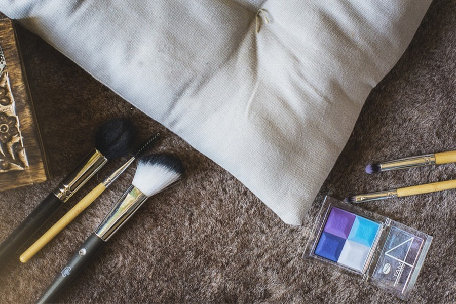 Makeup brushes lying around a cushion
