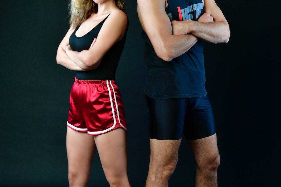 Man and woman posing in tank tops and shorts