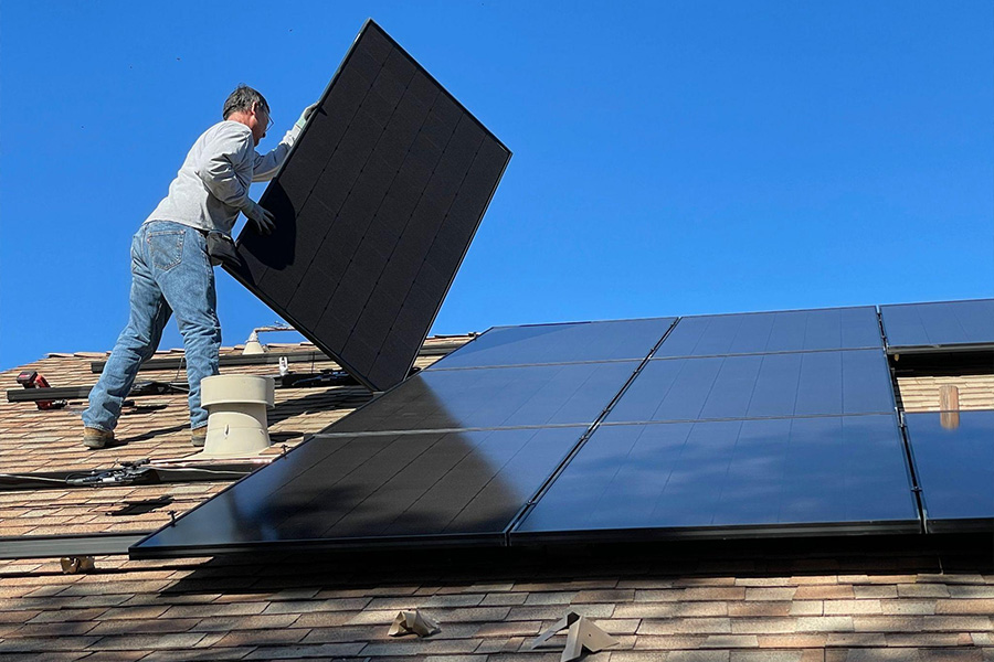 Man installing renewable energy system on a residential building