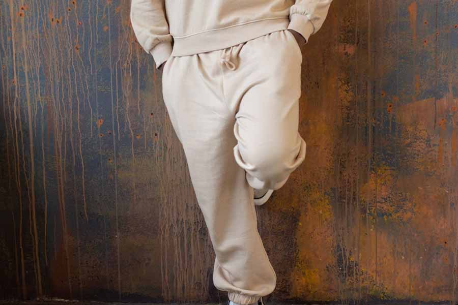 Man posing on wall rocking white baggy pants