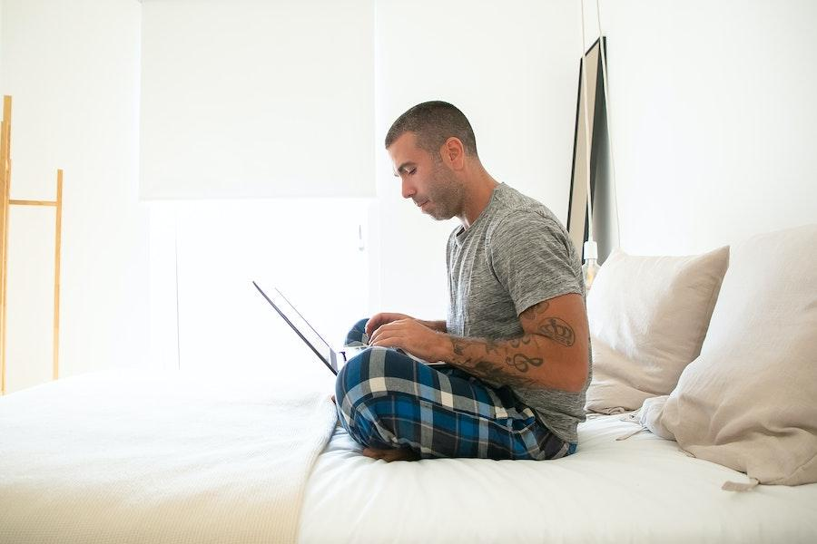 Man using a laptop while wearing pajamas