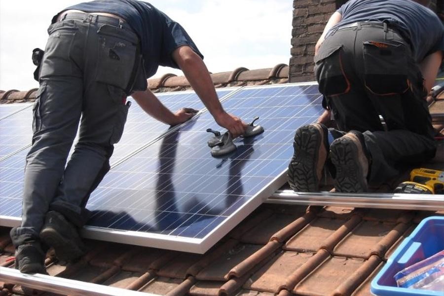 Men fixing solar panels on a rooftop