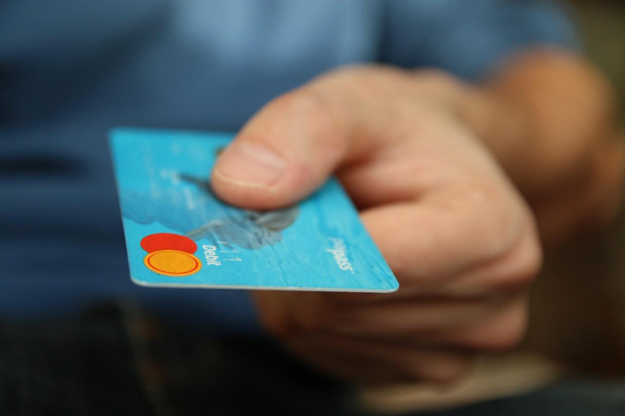 Person holding a debit card with his hand
