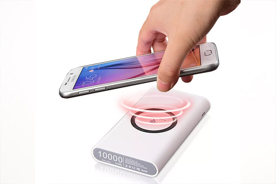 Person holding a smartphone near a wireless charging power bank