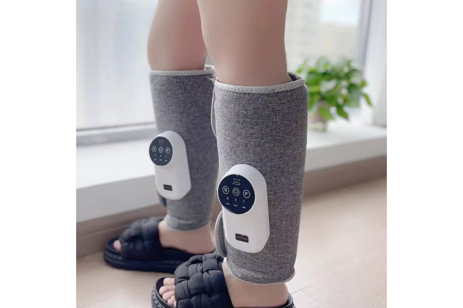 Person wearing electric leg massager on both lower legs