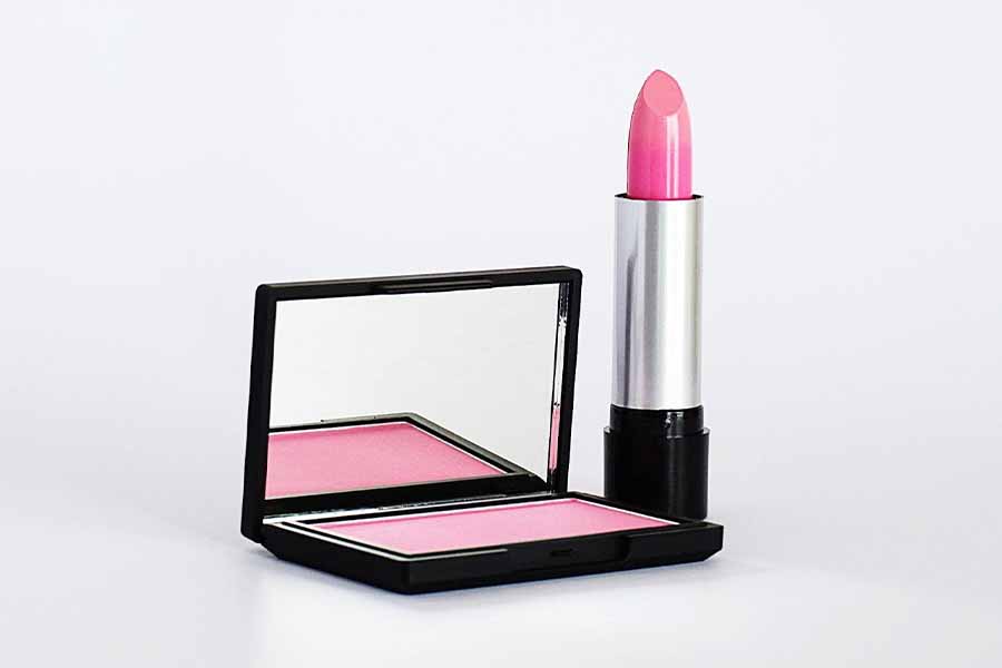 Pink lipstick next to a small mirror