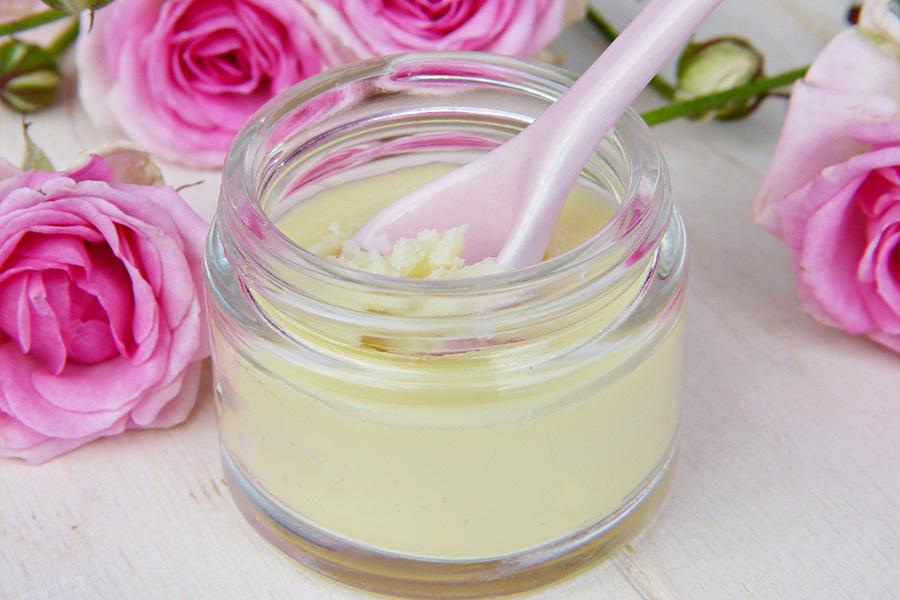 Spoon in cream surrounded by pink flowers