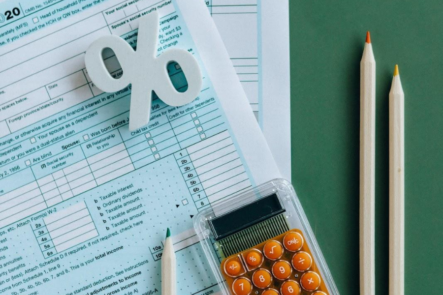 Tax documents on the table next to pens and a calculator