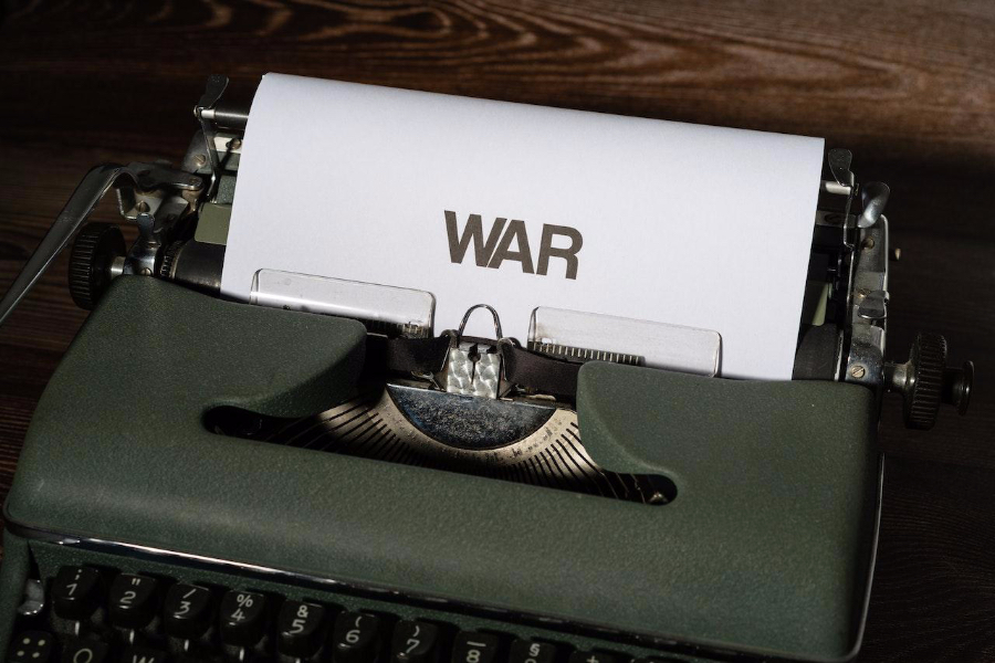 A palavra 'guerra' em papel branco em uma máquina de escrever mecânica