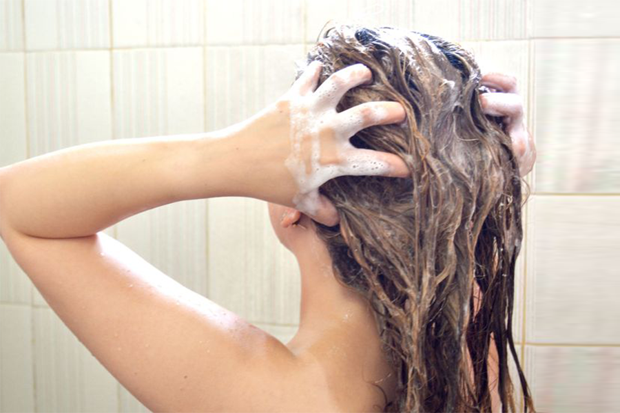 Woman applying hair mask in the shower