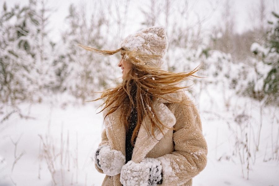Woman in the snow wearing a brown wool beanie