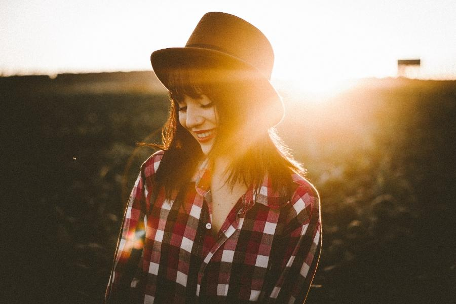 woman in white and red checkered dress shirt wearing a brown fedora hat