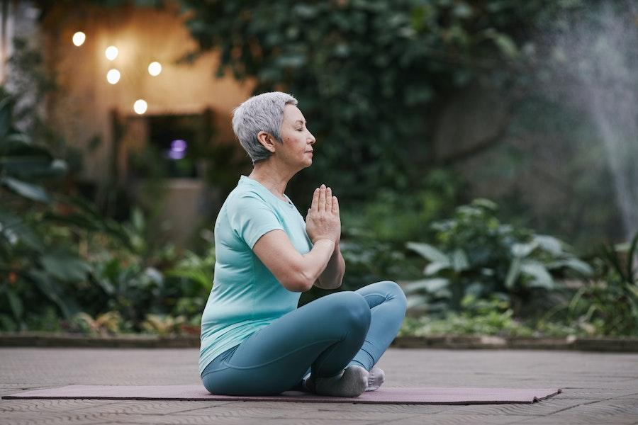 Woman meditating in a blue basic shirt and leggings