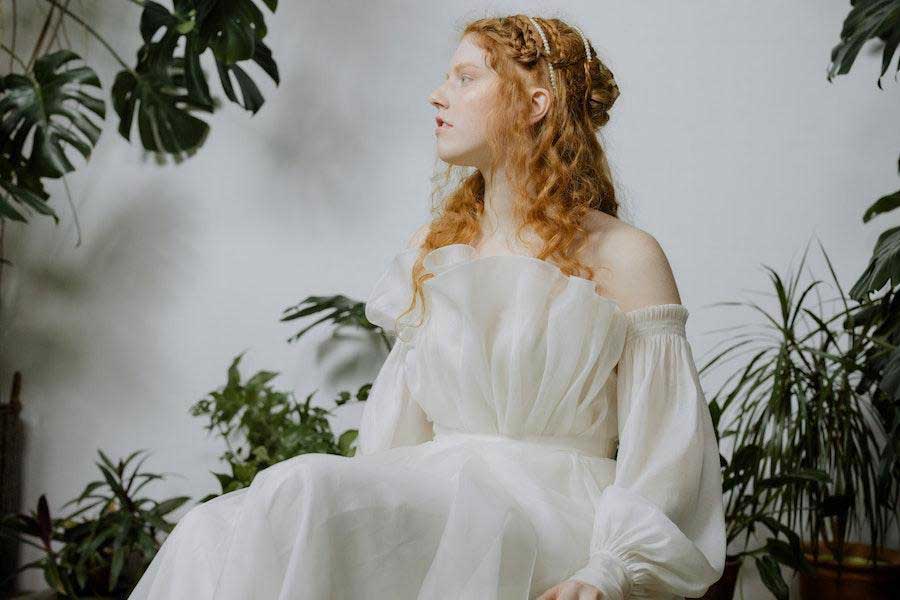 Woman sitting while wearing a white elegant dress