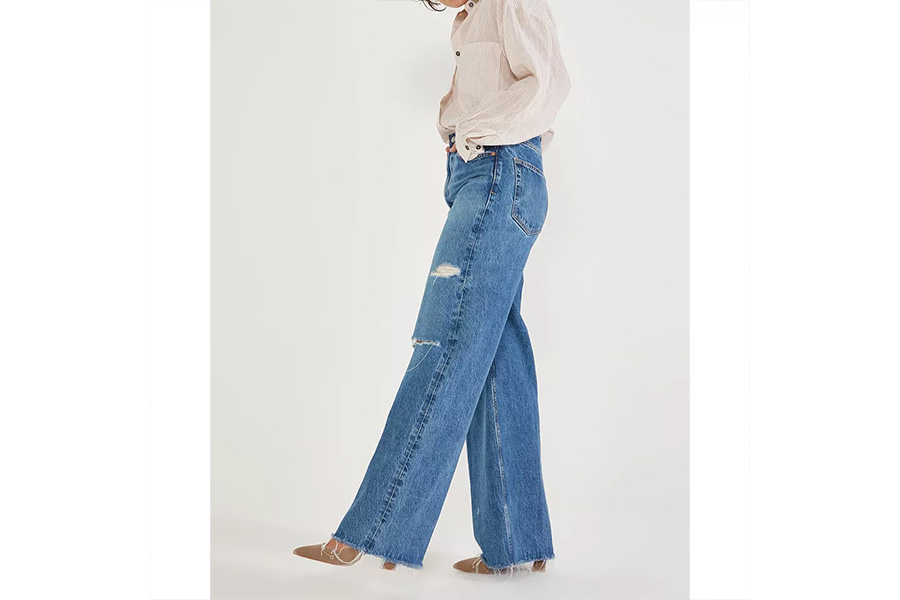 Woman wearing blue pair of mom jeans with brown boots