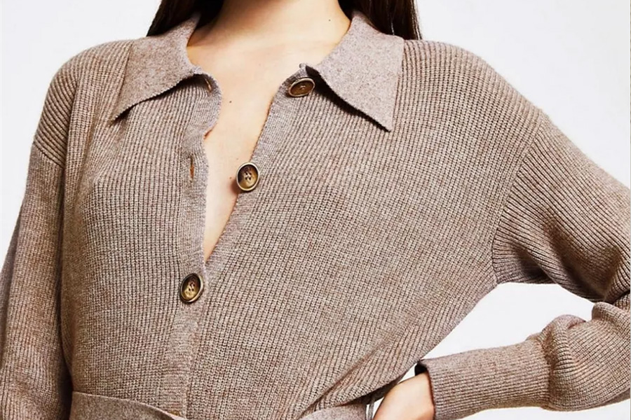 Woman wearing brown polo sweater dress with buttons and belt