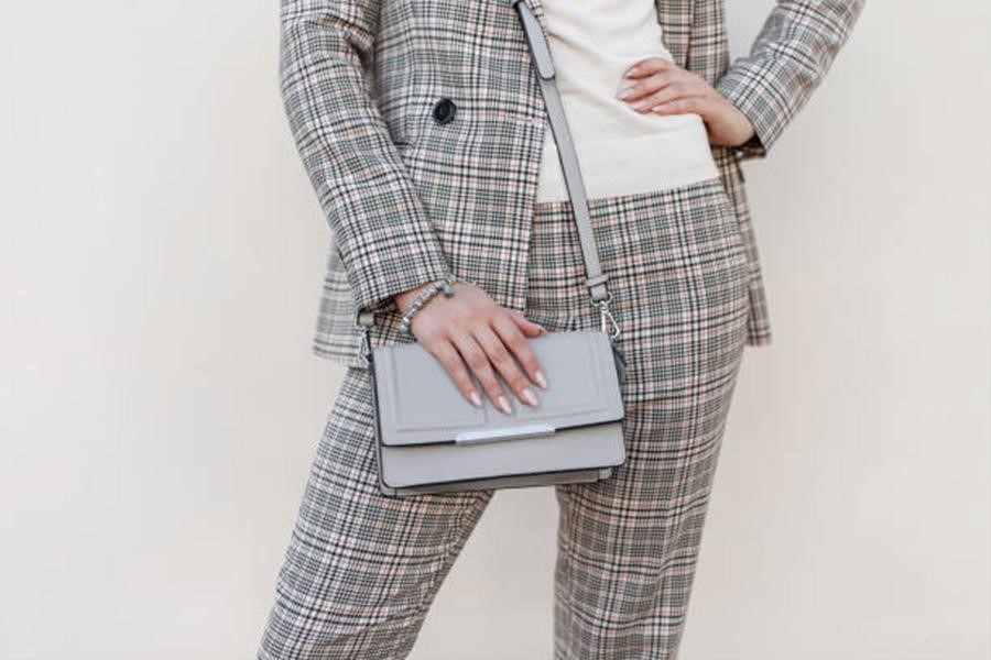 Woman wearing checkered pants with matching blazer and handbag