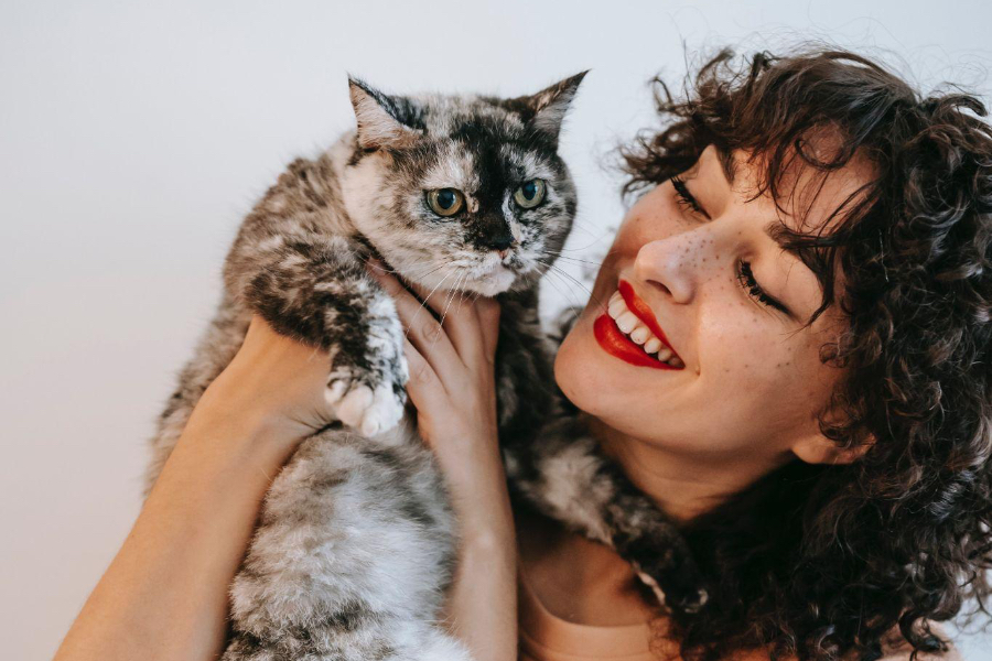 Woman with fluffy eyebrows holding a cat