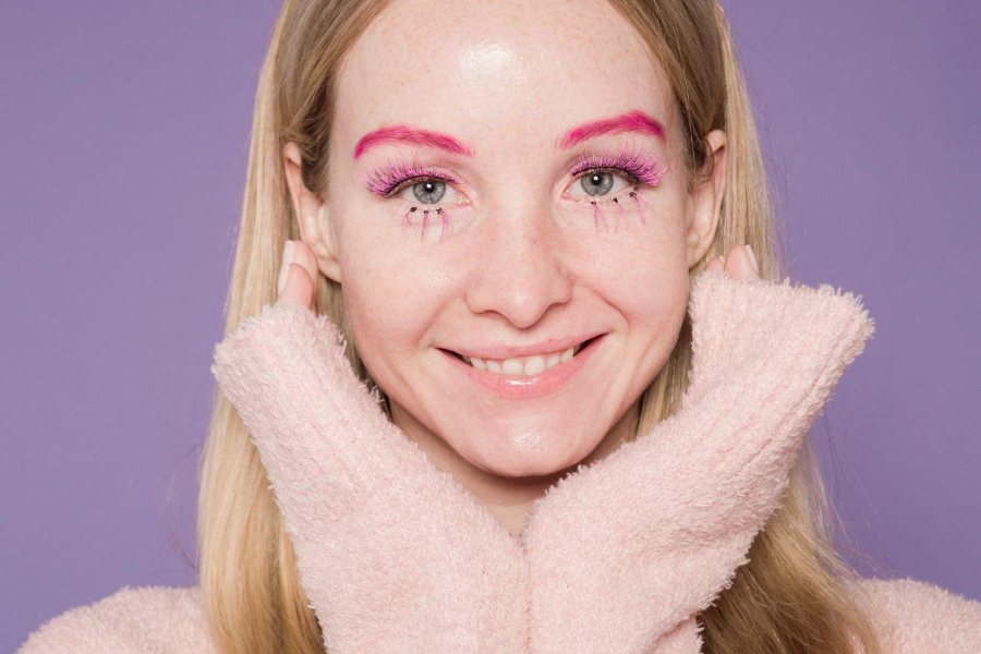 Woman with pink eyebrows and colorful eye makeup