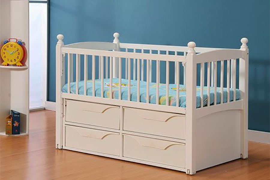 A white baby crib with a blue mattress