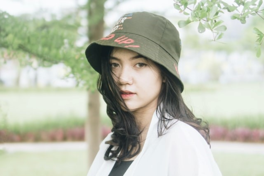 A woman wearing a military green printed twill bucket hat