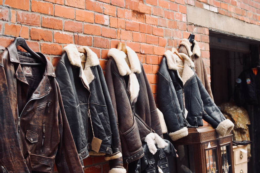 Collection of fur lined leather jackets hung on a wall
