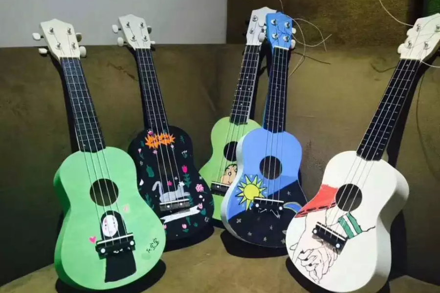 Five small acoustic guitars painted in different styles