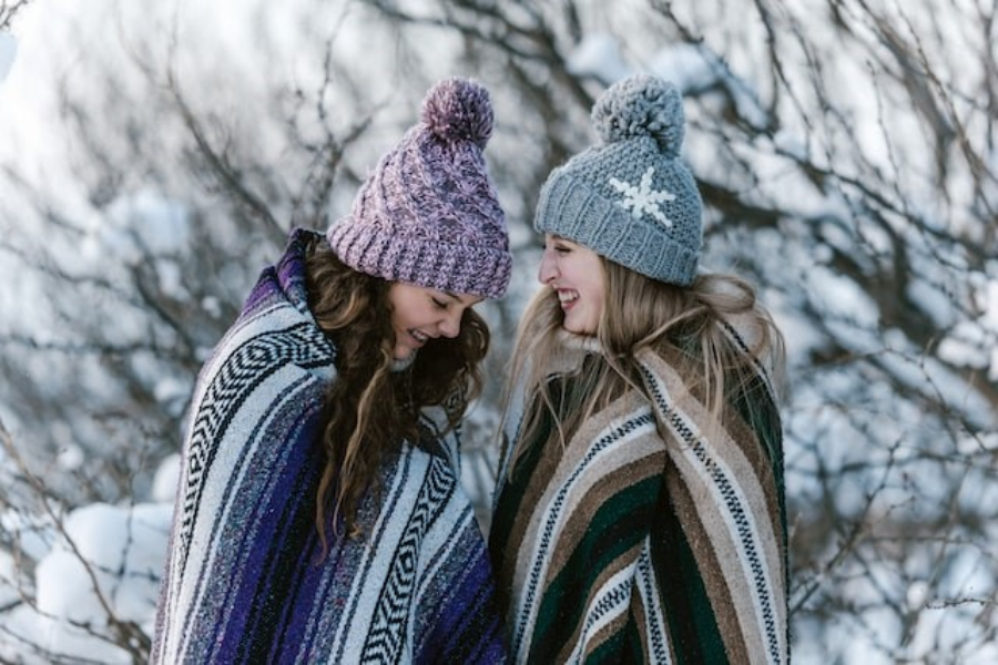 Two Women Wearing Multi-Colored Knit Beanie Hats