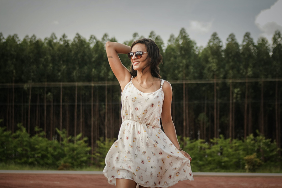 Woman wearing white floral dress and sunglasses