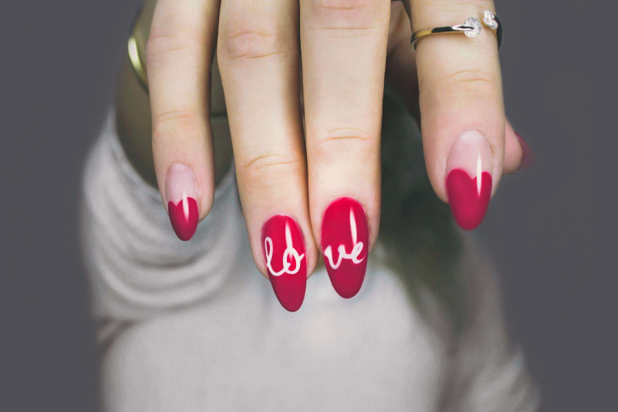 Woman with bold, pink, acrylic, almond-shaped nails