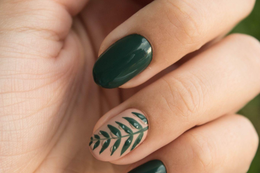 Woman with green nail polish and leaf 3D accent nail