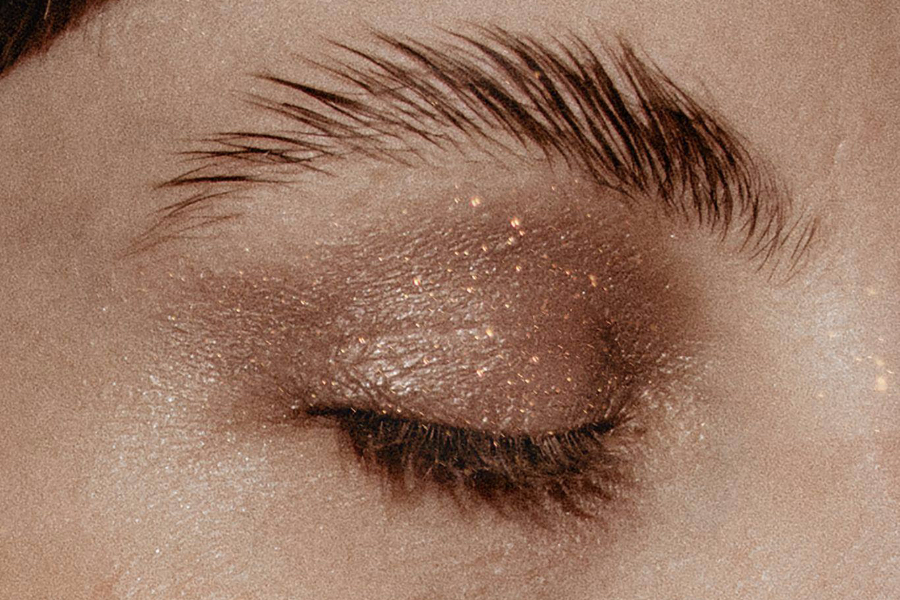 Woman with laminated brows and sparkly neutral eyeshadow