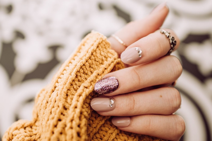 Woman’s hand with rhinestones on the cuticles